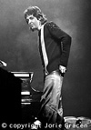 Paul standing by piano (image)